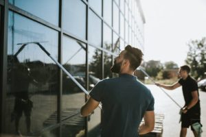 "فني محترف ينظف واجهة زجاجية لفيلا"